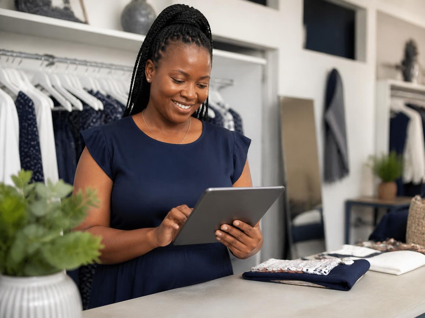 A smiling boutique owner using a tablet to register her business